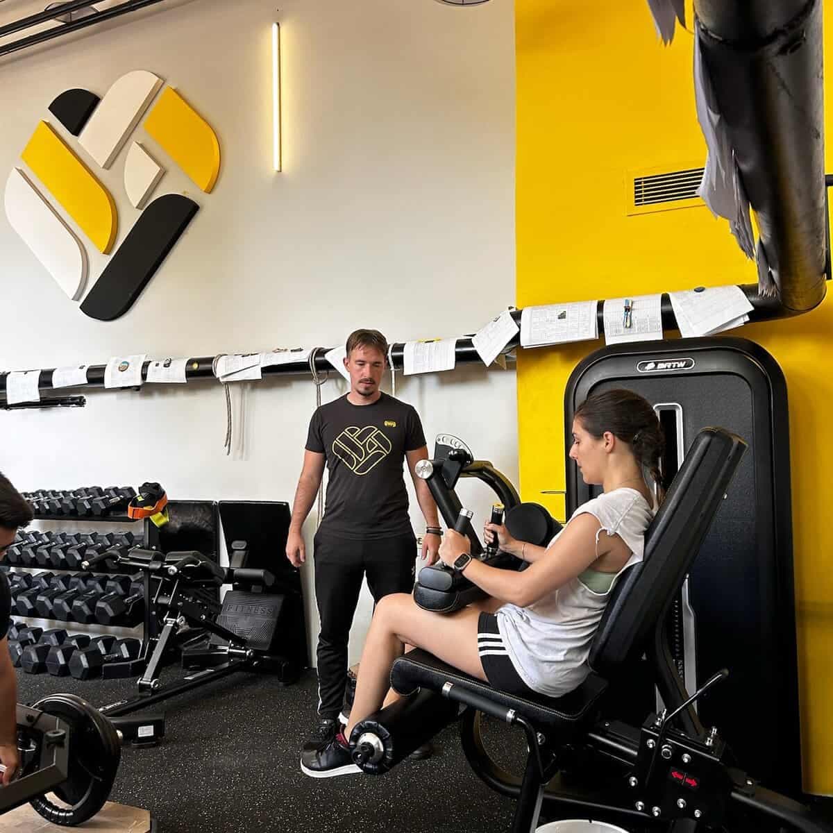 Trener uz vežbačicu na spravi u studiju Workout Team